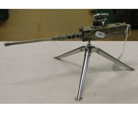 A table lighter modelled as a Browning machine gun, on folding chrome tripod stand.
