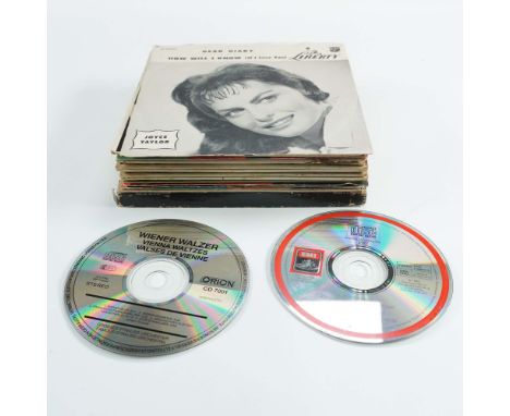 Collection of two compact discs and twelve 7-inch vinyl records featuring various artists and musical genres. The CDs include