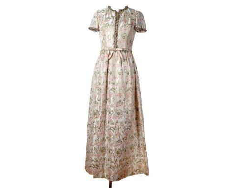Regal vintage full-length evening gown in a shimmering gold brocade with an ornate floral scroll pattern in soft tones of pin