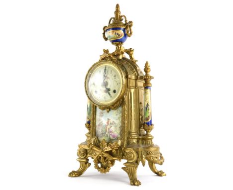 A 20thC continental mantel clock, the brass case decorated with scrolls, swags, etc., with painted dial above a ceramic panel