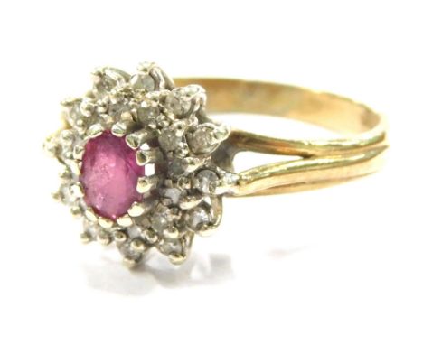 A 9ct gold ruby and diamond cluster ring, set with oval cut ruby in claw setting, surrounded by tiny diamonds, on raised shan