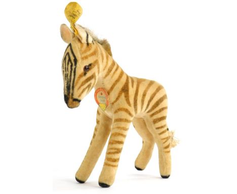 A vintage Steiff Zebra, with original paper label and pin or button to ear, 17cm long.