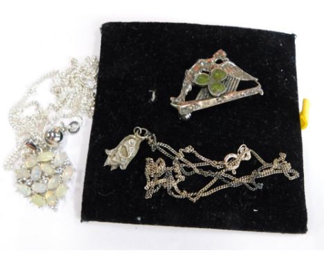 A group of costume jewellery, to include a silver imitation moon set pendant and chain, a silver pendant and a three leaf clo