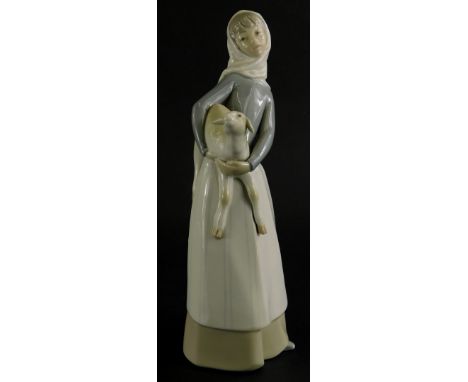A Lladro porcelain figure of a lady holding a lamb, 27cm high.