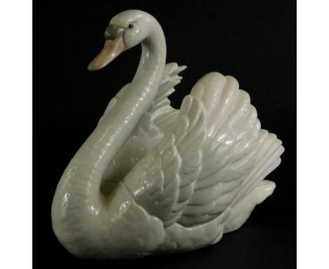A Lladro porcelain figure of a swan, 20cm long.