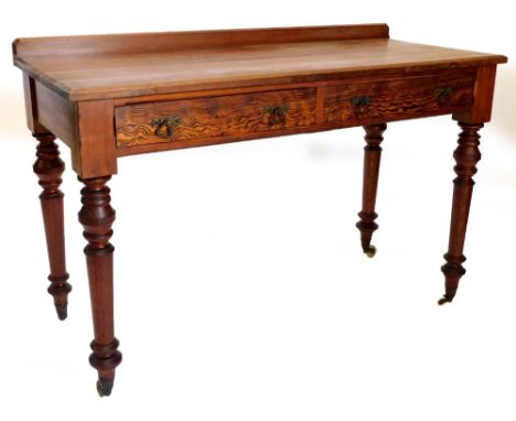 A Victorian pitch pine side or writing table, with a raised back above two frieze drawers, each with angular handles, on turn