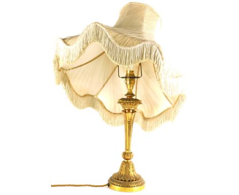 A continental gilt metal table lamp, cast with leaves on a tapering base, with decorative shade with metallic stitching, 57cm