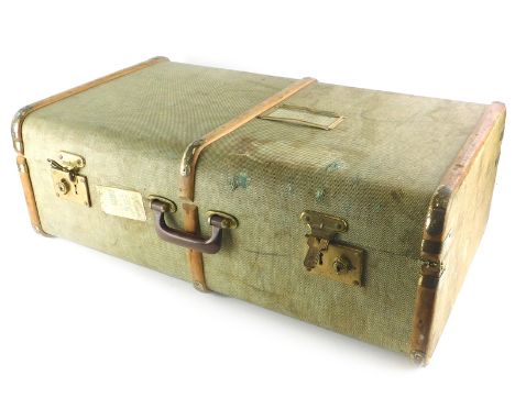 A green canvas and wooden bound suitcase or travel trunk, with brass effect metal mounts, British Railway luggage label for a