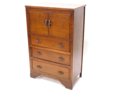 A 1920s oak tall boy, with two panel doors above three drawers on bracket feet, 76cm wide.
