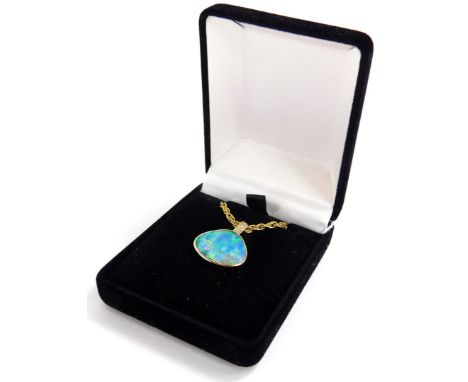 An opal and diamond pendant and chain, the opal doublet in a yellow metal surround stamped 585 14ct, with three diamond set t