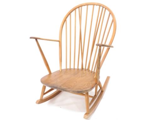 An Ercol rocking chair, the shaped back with spindle turned supports, curved arms and solid elm seat with rockers.  