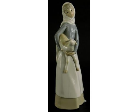 A Lladro porcelain figure of a lady holding a lamb, 27cm high.