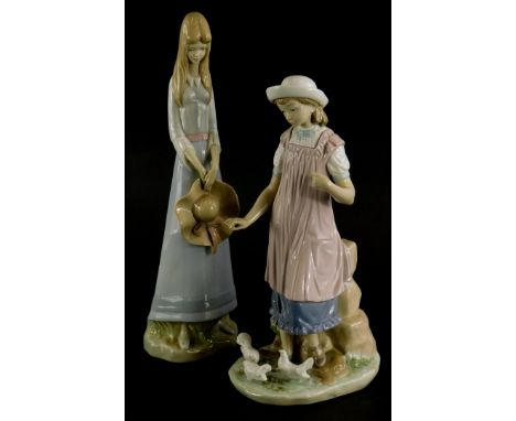 A Lladro porcelain figure of a young girl feeding doves, (AF), 28cm high, and a Spanish porcelain figure of a girl with a bro