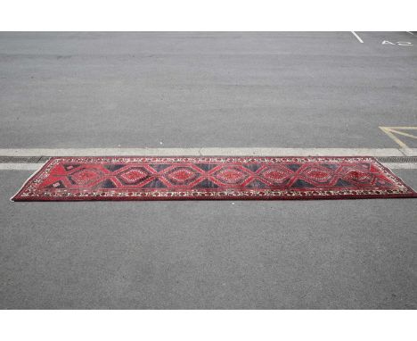 A NORTH-WEST IRANIAN MESHKIN RUNNER A NORTH-WEST IRANIAN MESHKIN RUNNER, the dark red field with seven dark blue medallions w