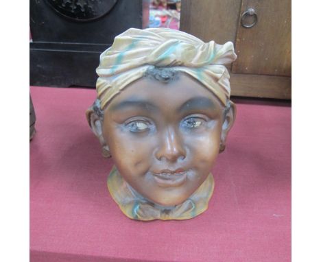A Continental Bisque Pottery Tobacco Jar, circa 1900, as a Negro boys head with cover as a turban, 13cm high.