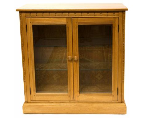 An Ercol light elm and ash glazed display cabinet bookcase, with glass shelves, fitted for electric lights, 96cm wide, 96cm h