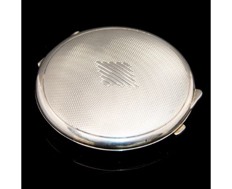 An Art Deco silver compact, circular form, engine turned with stepped baton diamond to the centre, Turner and Simpson, Birmin