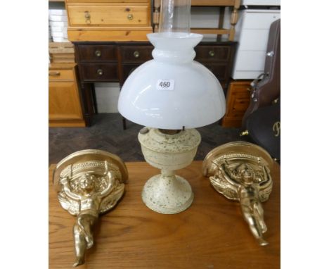 A cream painted oil lamp with shade and a pair of gilt cherub wall brackets 