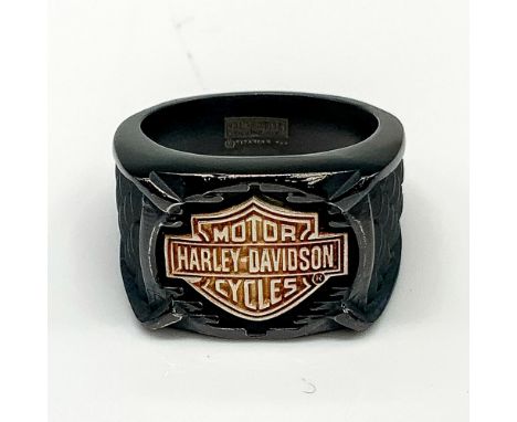 Black band with a large copper tone Harley Davidson logo in the front and textured dark grey scales carved on either side. Ti