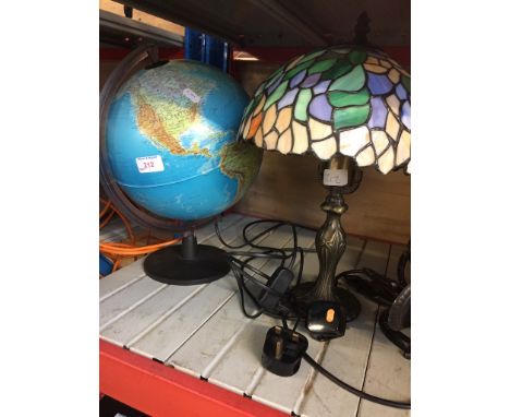 AN ILLUMINATED GLOBE AND A TIFFANY STYLE LAMP