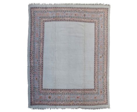 USHAK CARPET  WEST ANATOLIA, EARLY 20TH CENTURY   the plain cream field within light blue palmette and foliate vine border  3