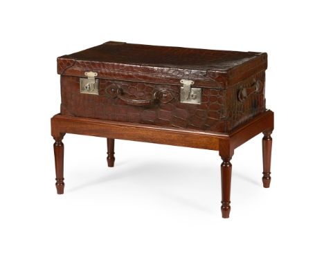 CROCODILE SKIN TRUNK ON STAND  EARLY 20TH CENTURY, THE STAND LATER   with side handles and chromium plated locks marked 'Brit