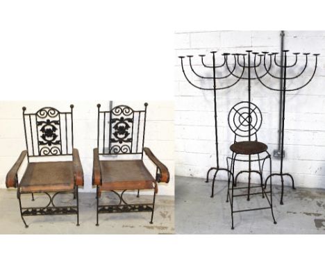 A pair of Edwardian Arts and Crafts style cast iron garden chairs with floral and leaf design to back centre panel, to curvin