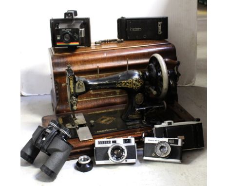 An early 20th century walnut and inlaid cased sewing machine (locked) and a small collection of vintage cameras to include a 