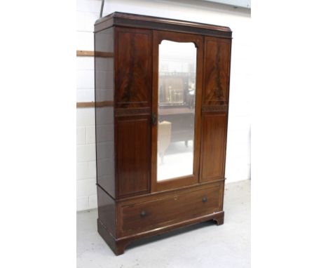 An Edwardian mahogany single-door wardrobe with Greek key carved decoration above a single drawer to bracket feet, width 119c