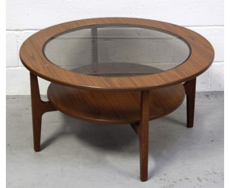 A retro G-Plan circular teak coffee table with glass top above lower shelf, on tapering supports, diameter 84cm. CONDITION RE
