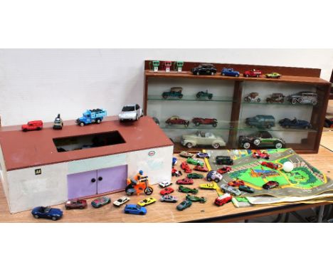 A scratch-built garage with vintage toys and cars to the interior and a small display case with sliding glass doors and inter