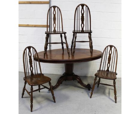 An early 20th century mahogany oval tilt-top dining table on column and carved trefoil supports, length 142cm and four Ercol-