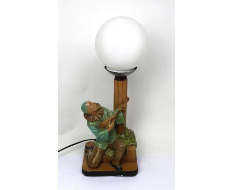 An Art Deco table lamp modelled as Pierrot with lute beneath street lamp, opaque white glass globe, height, excluding fitting