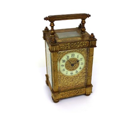 A c1900 brass carriage clock, the white enamel dial set with Arabic numerals, gilded and fluted case, inscribed 'Presented to