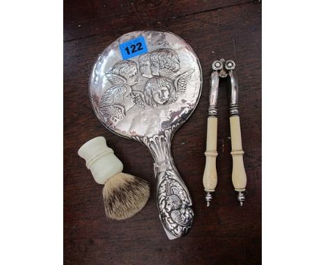 A silver hand mirror, nut cracker and shaving brush