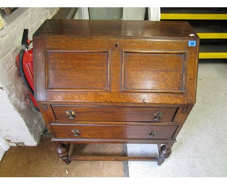 An early 20th century oak bureau, the fielded fall flap revealing fitted pigeonholes interior and leather scriber over one sh