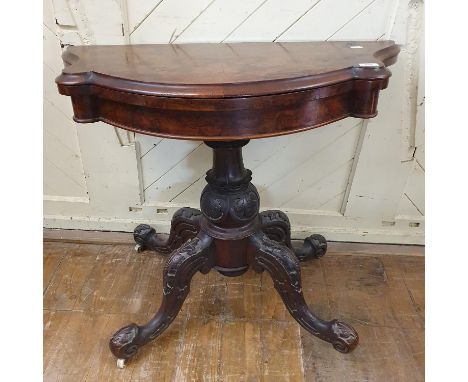 A Victorian card table, the shaped top veneered in burr walnut, on a carved base, 92 cm wide

 