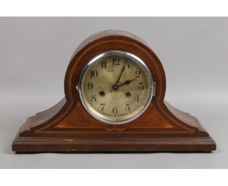 A mahogany dome top oak cased mantle clock with marquetry and twin train movement.