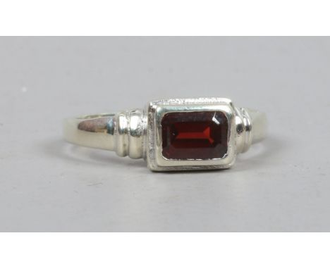 A 9ct white gold and garnet ring, size R.