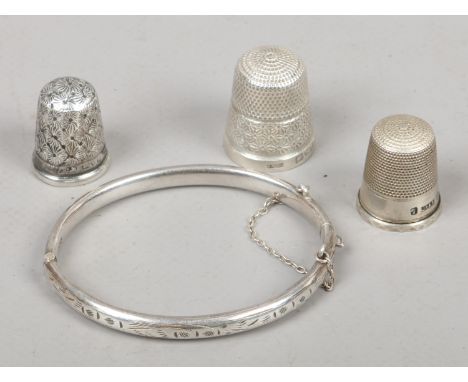 A Charles Horner silver bangle and thimble along with two other silver thimbles, total weight 15.1 grams.