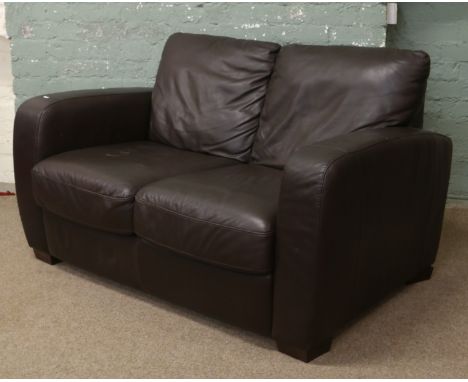 A brown leather two seater sofa.