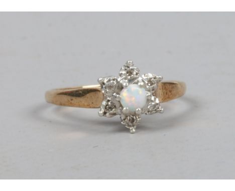 A 9ct gold opal and diamond ring, set in a daisy cluster size O