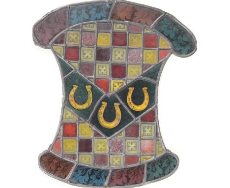 A Northern European stained and leaded glass pseudo-armorial window light, 19th/early 20th c, with a bend of three horseshoes