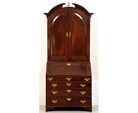 A George II walnut bureau bookcase, the segmental cornice above arched doors with raised and fielded panels enclosing adjusta