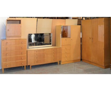 A Meredew light oak bedroom suite, 1960s, comprising two wardrobes, dressing table, chest of drawers and bedside cupboard 