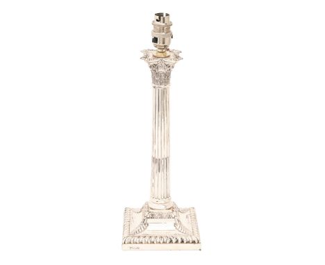 An Edwardian silver column candlestick, the stop fluted shaft on flared square foot with acanthus leaves and gadrooned rim, n