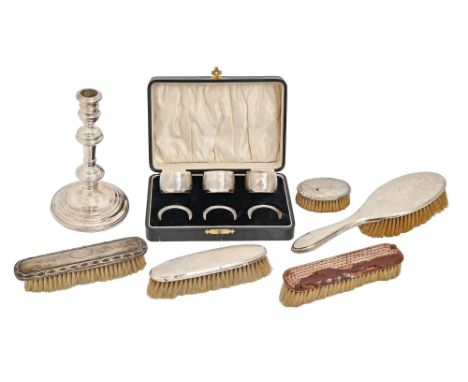 A set of three George V silver napkin rings, with Bakelite core, marks rubbed, Birmingham 1930, a silver candlestick, London 