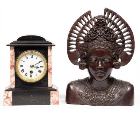 A Belgian slate mantle timepiece, c.1900, with enamel dial, pendulum and key, 26cm h, and a Balinese carved hardwood bust of 