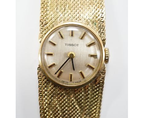 A lady's 9ct gold Tissot manual wind wrist watch, on a 9ct bracelet, 16cm, gross weight 27.9 grams.