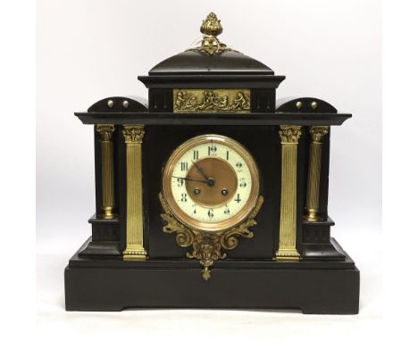 A black slate mantel clock with gilded pillars, striking on a coiled gong, 41cm high